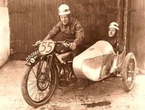 Black and white photo of Freddie Dixon on a Douglas motorcycle with passenger Thomas Denney in the sidecar 