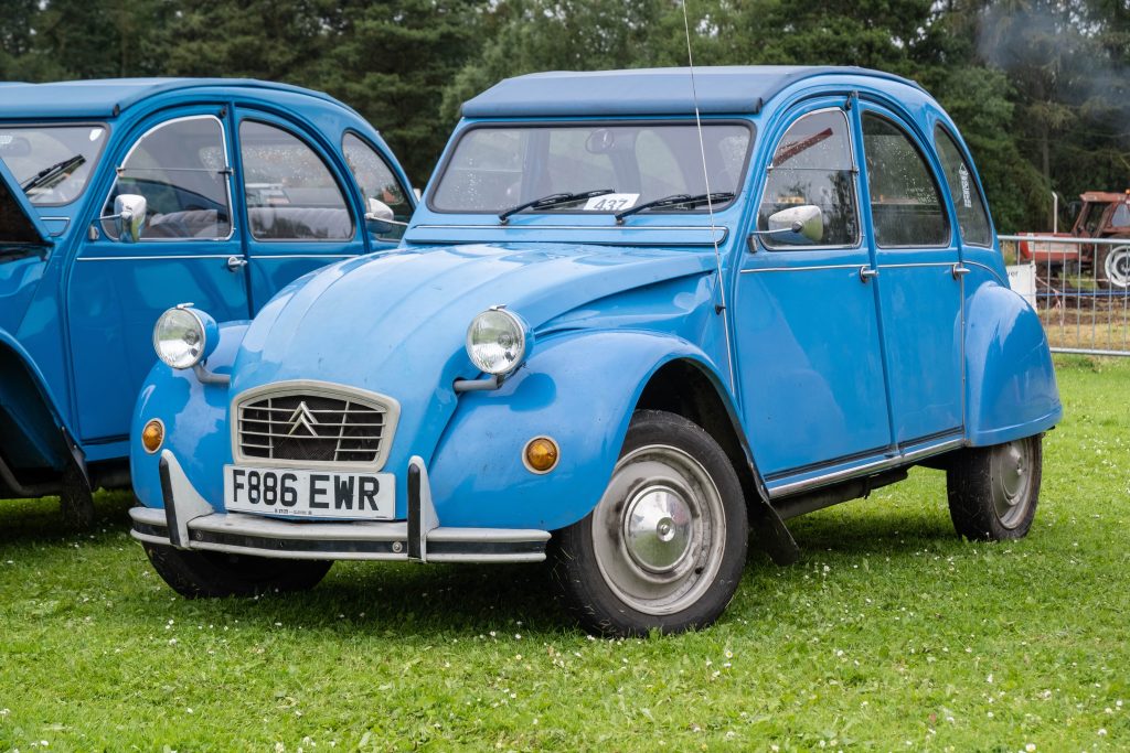 Blue Citroen 2CV in a field at a classic car show