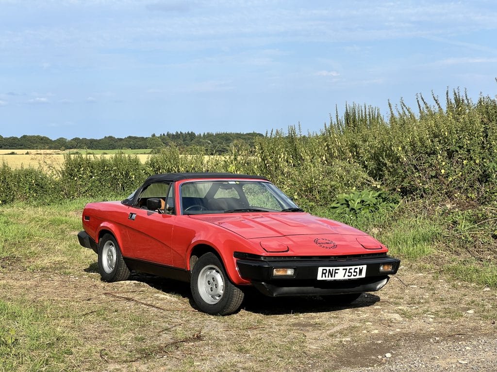 Scenic field landscape featuring red Triumph TR7 on loan from TR Register Car Club in Classic Car Loan Project