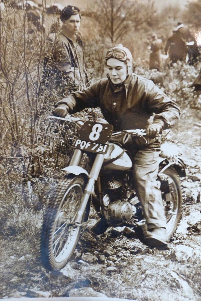 Black and white photo of Olga Kevelos on a vintage motorcycle